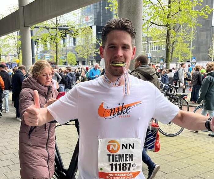 Foto van Ztorm founder Tiemen Storm, met een medaille in zijn mond, na het lopen van een Marathon