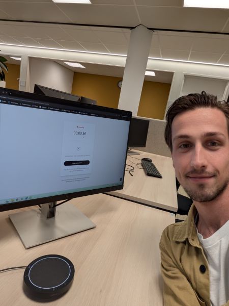 Selfie van trainee Paul aan zijn bureau, bij opdrachtgever StJansdal