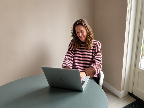 Young professional Alon aan het werk op haar laptop bij haar opdrachtgever Kracht Den Haag