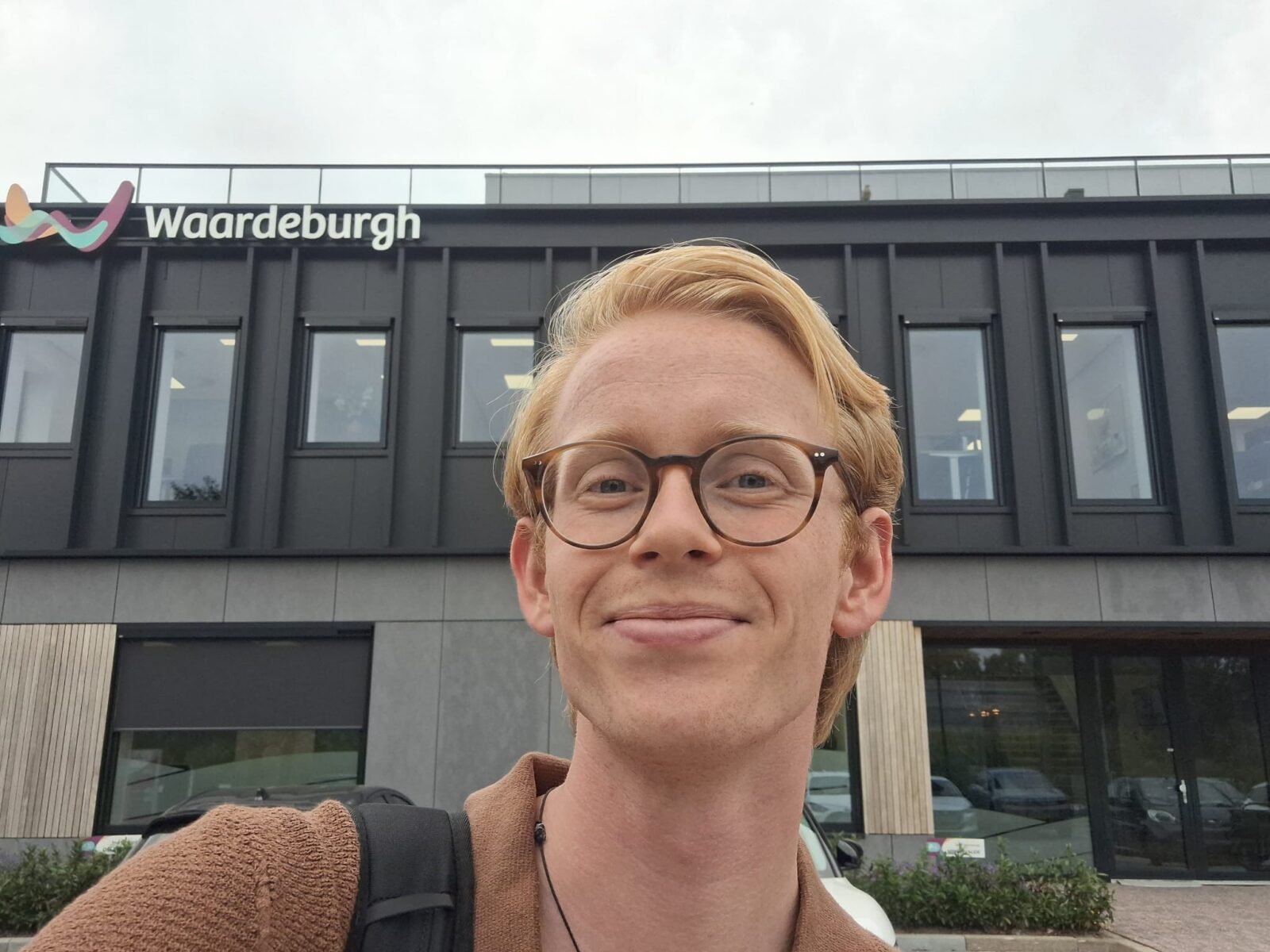 Selfie van Ztormer Matthias, met de gevel van opdrachtgever Waardeburgh op de achtergrond