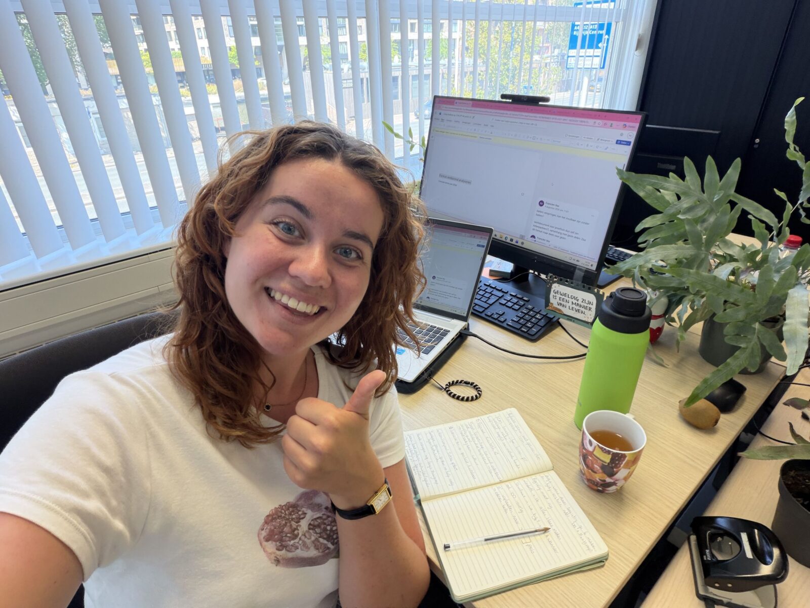 Selfie van Ztormer Francien aan haar bureau bij haar opdrachtgever met haar duim omhoog